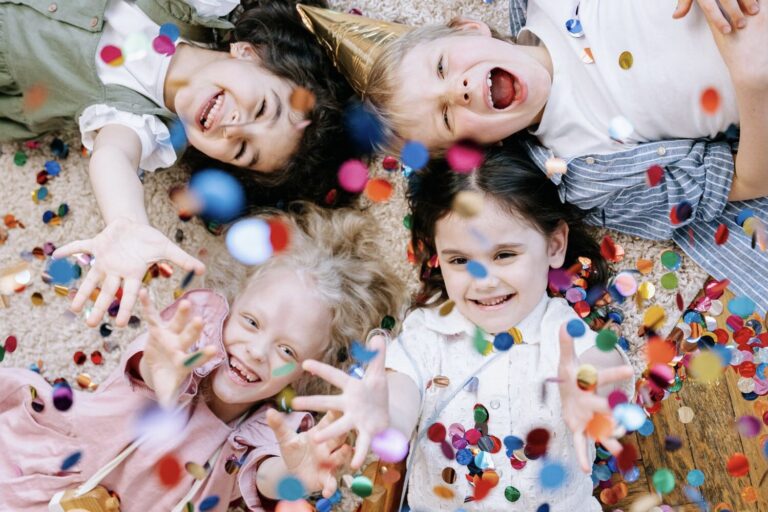 Children lying on the floor throwing confetti