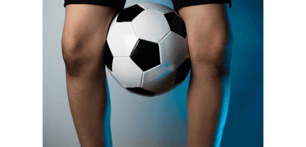 Boy with football between his knees