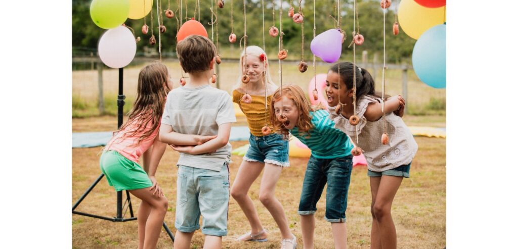 Kids eating donuts off a string