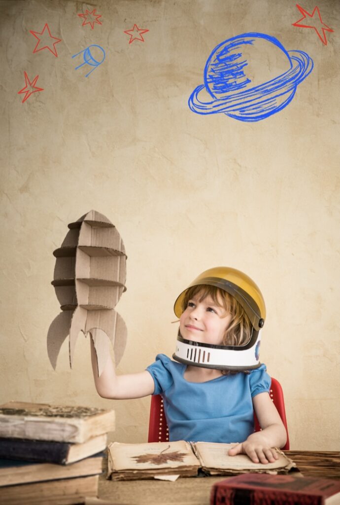 Young boy with a cardboard model rocket