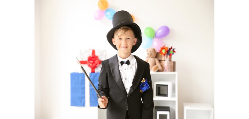 Boy dressed in magicians outfit with magic wand