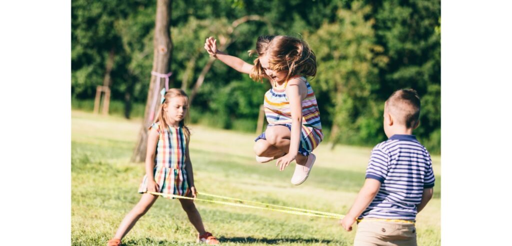 Three children playing french skipping elastics