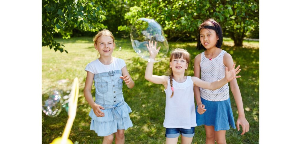 Girls playing with large bubbles in the park