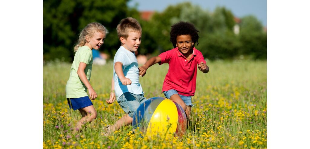 Children playing with a beach ball in the park