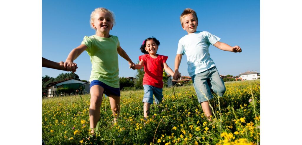Children holding hands running in the park