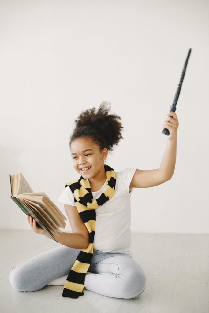 A girl holding a spell book and a wand, casting a spell