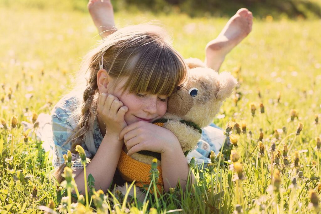 A young girl cuddling a teddy bear