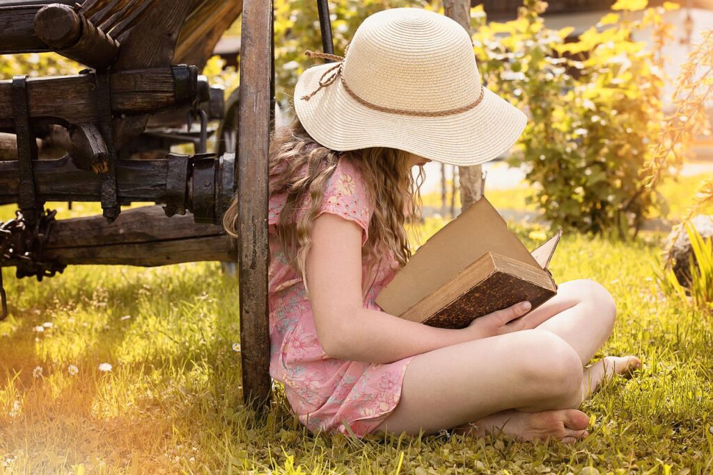 A girl reading a book in the outdoors