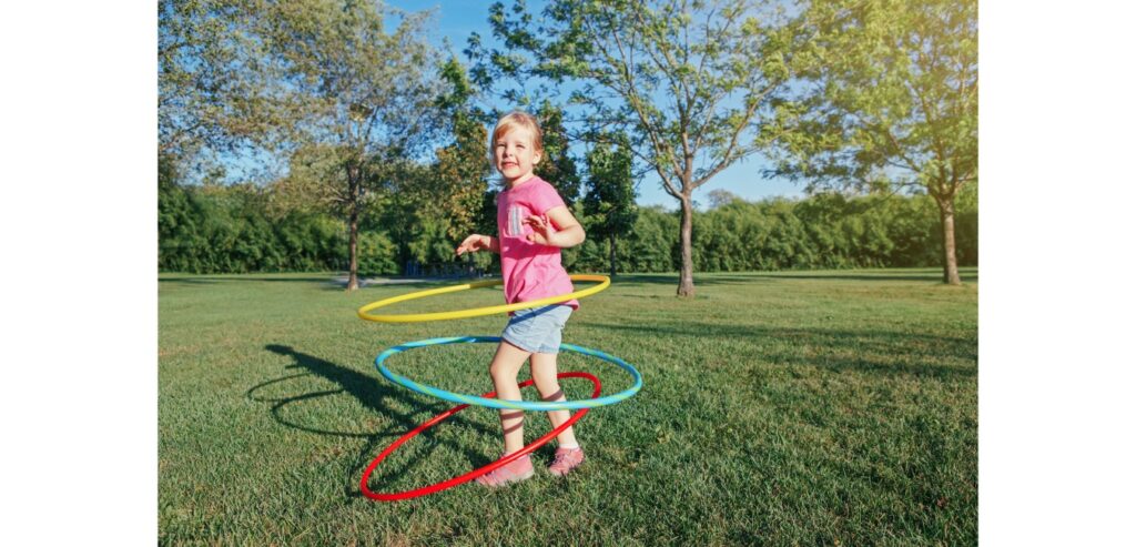 A girl with three hula hoops in the park