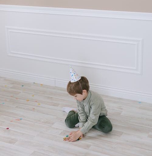 Little boy on his own wearing a party hat