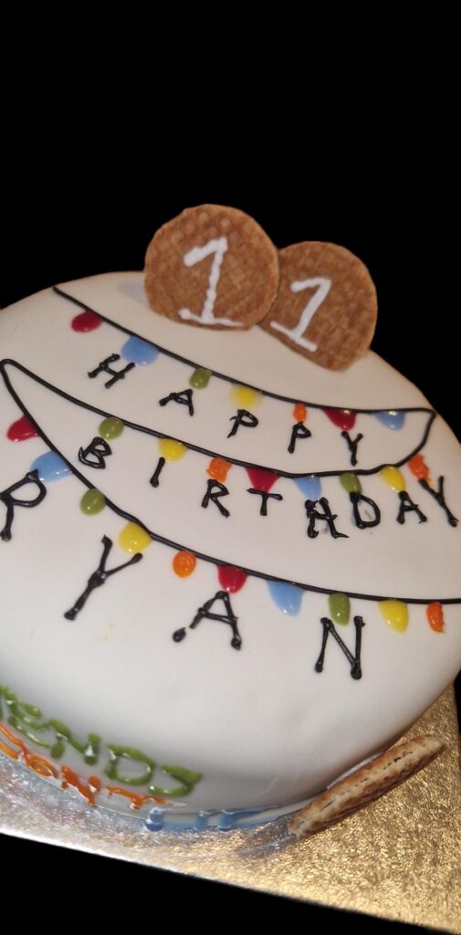 A stranger things inspired cake with fairy lights