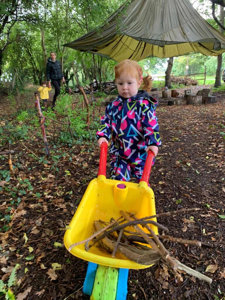 Lily collecting sticks - Forest school style parties