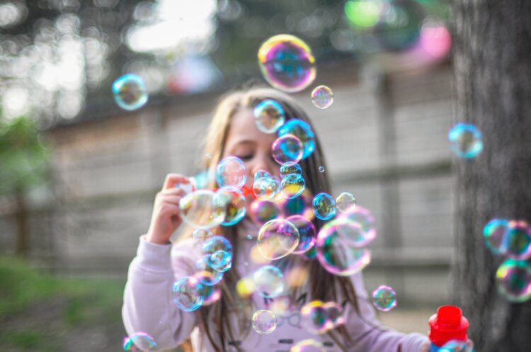 A little girl blowing bubbles
