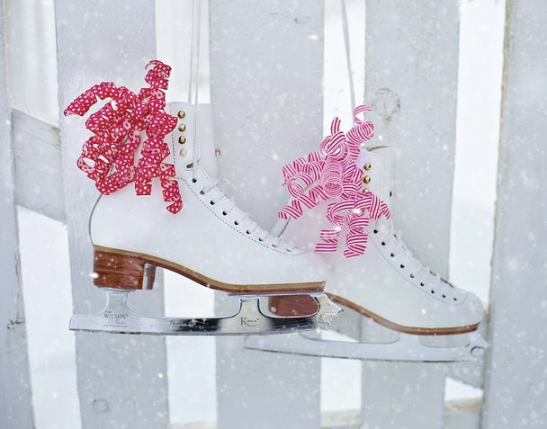 Ice skating boots hanging on fence