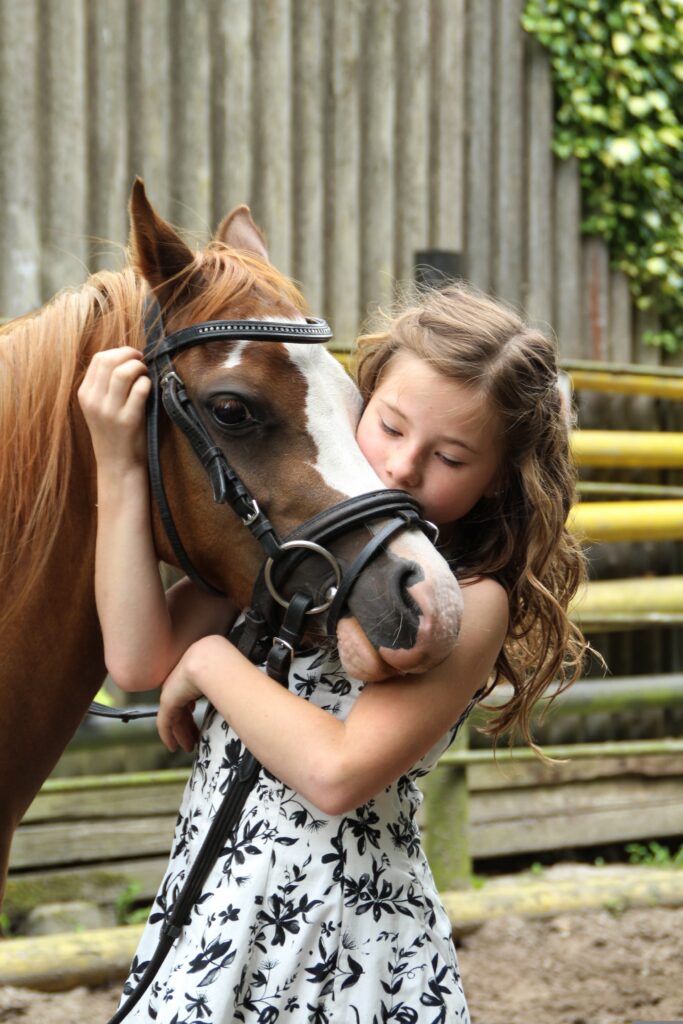 Girl cuddling pony