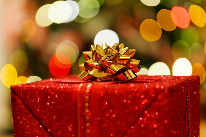A red christmas gift box with a gold rosette