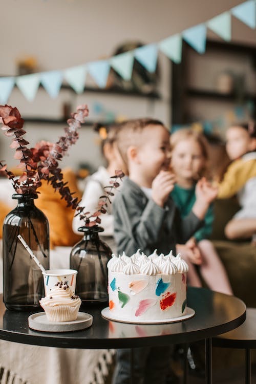 Birthday cake in foreground of a party