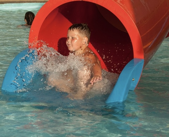Young boy at the bottom of a water slide