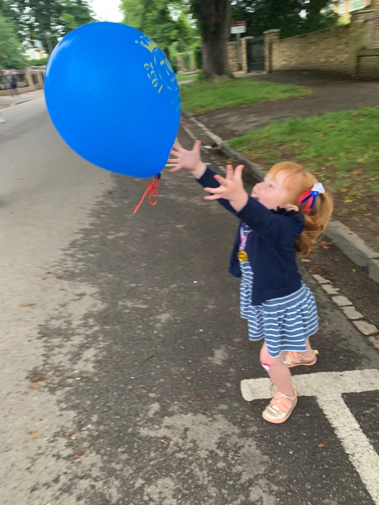 Girl reaching for a balloon - Coronation games and activities for kids