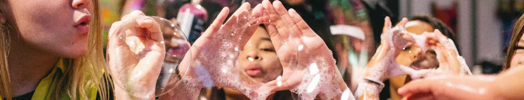 Girl blowing bubbles though her hands
