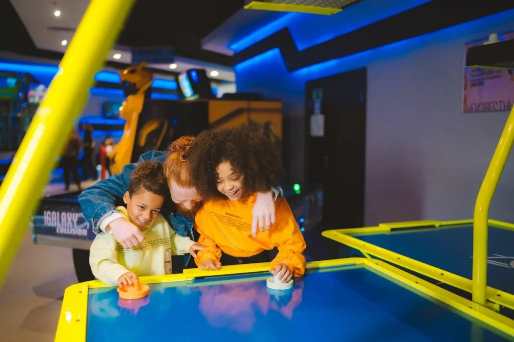 Kids playing air hockey arcade game